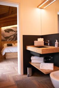a bathroom with a sink and a bed at Garni Le Grigne in Barzio