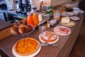 una mesa con pasteles y pasteles y otros alimentos. en Garni Le Grigne, en Barzio