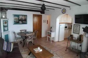a living room with a table and a kitchen at Casa Karim in Mojácar