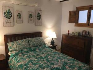 a bedroom with a bed with a green comforter and a window at Casa Karim in Mojácar