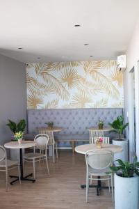 a restaurant with tables and chairs and a wall with a mural at Hotel Santa Clara Boutique in Montería