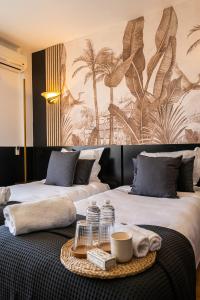 a hotel room with two beds with a tray of towels at Hôtel Gallia Cannes in Cannes