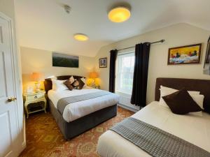 a bedroom with two beds and a window at Fairlight Guesthouse in Glenridding