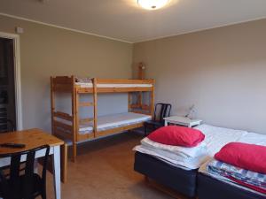 1 dormitorio con 2 literas y mesa en Vena Värdshus, en Vena