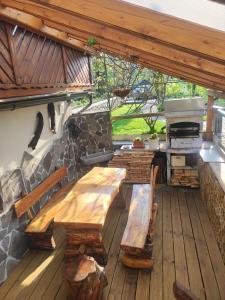 un patio con bancos de madera y un horno de piedra. en Apartma Vintgar, en Bled
