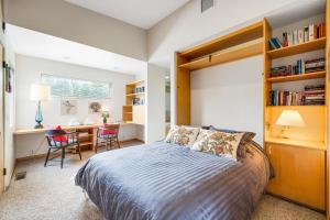 een slaapkamer met een bed en een bureau met stoelen bij Aloha House in Sea Ranch