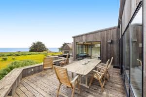 a wooden deck with a table and chairs on it at Aloha House in Sea Ranch