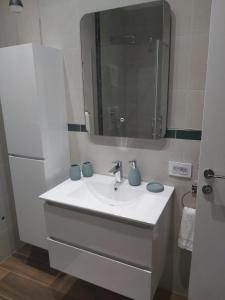 a bathroom with a white sink and a mirror at Apartman Golden in Senta