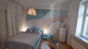 a bedroom with a bed and a striped wall at Home S in Zagreb