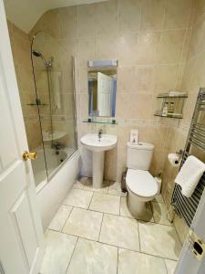 a bathroom with a toilet and a sink and a shower at Fairlight Guesthouse in Glenridding