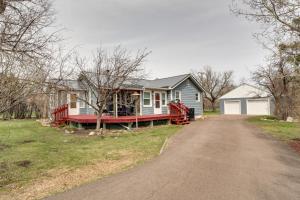 a blue house with a red porch on a driveway at Inviting Missouri River Vacation Rental 2 Mi Away in Great Falls