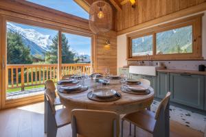 a wooden dining room with a table and a large window at Sublime Semi Detached Chalet Facing The Mont Blanc in Chamonix