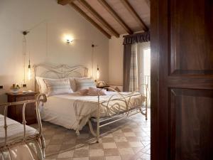 a bedroom with a white bed and a window at Tenuta Montemagno Relais & Wines in Montemagno
