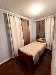 a small bedroom with a bed with white curtains at Finca el Calar El mejor lugar para buscar la paz in Empalme
