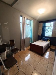 a bedroom with a bed and two chairs and a window at Finca el Calar El mejor lugar para buscar la paz in Empalme