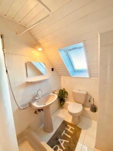 a bathroom with a sink and a toilet and a window at Sailor's Apartman in Siófok