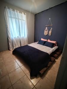 ein Schlafzimmer mit einem großen Bett mit blauer Wand in der Unterkunft Finca el Calar El mejor lugar para buscar la paz in Empalme