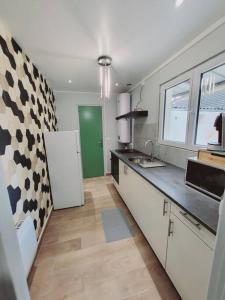 Il comprend une cuisine avec un réfrigérateur blanc et une porte verte. dans l'établissement Family flat Stade de France airport CDG Le Bourget "Appart'7", à Pierrefitte-sur-Seine