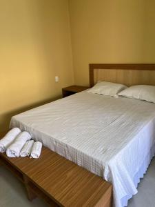 a bedroom with a bed with two towels on a table at Hotel do Carmo in Piracuruca