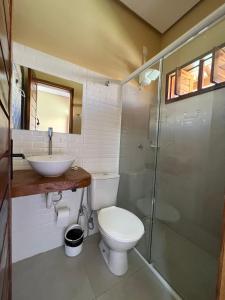 a bathroom with a toilet and a sink and a shower at Hotel do Carmo in Piracuruca