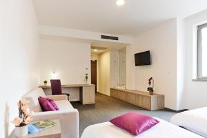 a hotel room with a bedroom with a living room at Hotel Meksiko in Ljubljana