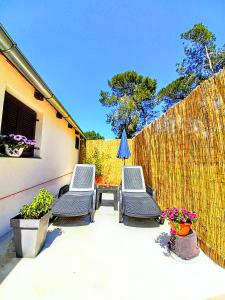 eine Terrasse mit zwei Stühlen, einem Tisch und einem Sonnenschirm in der Unterkunft Pampas studio, self check-in, private parking in Poreč + 12 Fotos