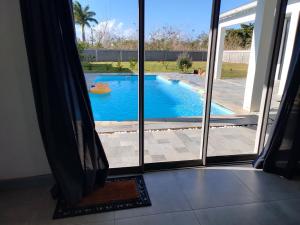 a view of a swimming pool through a window at Le Reposier 