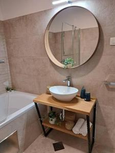 a bathroom with a sink and a mirror and a tub at Grand Amore Apartment in Dubrovnik