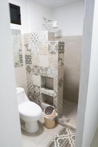 a bathroom with a toilet and a tiled wall at Summer Specials! 800 M to Samara Beach! Outdoor Workspace in Sámara