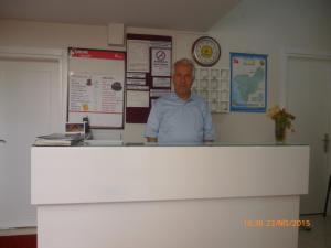 a man standing behind a counter in a room at Cicek Hotel & Apartments in Fethiye