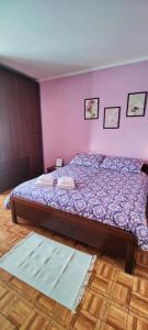 een slaapkamer met een bed met een paarse muur bij Domus - IL GIRASOLE in Montecelio