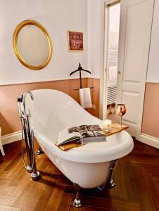 een bad met een boek erop in de badkamer bij Macchiato Suites Boutique Guest House in Napels
