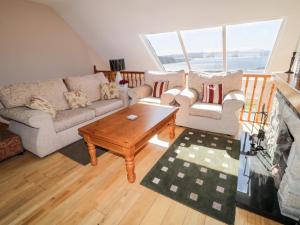 a living room with a couch and a coffee table at Inverbeg Cottage 2 in Downings