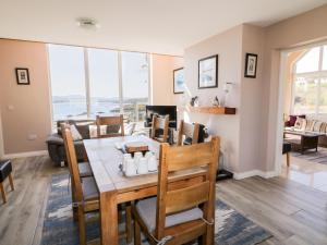 a dining room and living room with a table and chairs at Inverbeg Cottage 2 in Downings