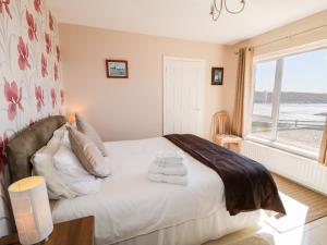 a bedroom with a bed with towels on it at Inverbeg Cottage 2 in Downings