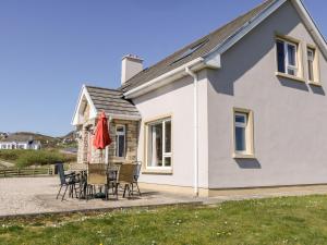 a house with a table and chairs in front of it at Inverbeg Cottage 2 in Downings