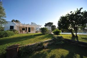 a yard with a white house with a tree at CASA NEL VERDE CON GIARDINO E PISCINA PRIVATA in Polignano a Mare