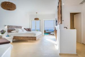 a bedroom with a bed and a view of the ocean at KLIDON Dreamy Living Suites in Mýkonos City