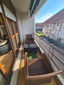 a balcony with chairs and a couch on a building at Acogedor dúplex en urbanización con piscina en Ajo in Ajo