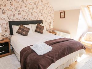 una camera da letto con un letto e asciugamani di Inverbeg Cottage 1 a Downings