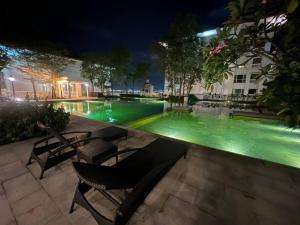 a swimming pool with green water at night at 2Beds Seaview Straits Quay comes with Carpark and Hothub in Bagan Jermal