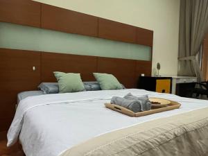 a bed with a wooden headboard and a wooden tray on it at 2Beds Seaview Straits Quay comes with Carpark and Hothub in Bagan Jermal