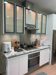 a kitchen with white cabinets and a stove top oven at 2Beds Seaview Straits Quay comes with Carpark and Hothub in Bagan Jermal
