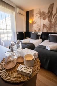 a room with two beds and a table with cups and drinks at Hôtel Gallia Cannes in Cannes