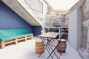 a patio with a bench and a table and barrels at Costa D'Ouro in Castelo de Paiva