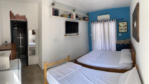 Habitación pequeña con 2 camas y TV. en SUÍTE PRIVATIVA RIVIERA & ITAGUARÉ 100mts de 2 praias!, en Bertioga