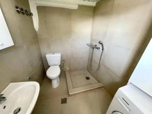 a bathroom with a shower and a toilet and a sink at Black Pebble Myconian House in Ano Mera +5 photos