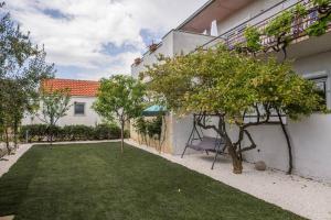 um quintal com árvores e um edifício em New apartment with pool and jacuzzi only for you em Kaštela