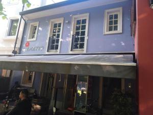 a blue building with awning in front of it at AFFITTACAMERE PIAZZA UNITA' in Monfalcone +11 photos