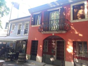 a red building with a balcony on the side of it at AFFITTACAMERE PIAZZA UNITA' in Monfalcone